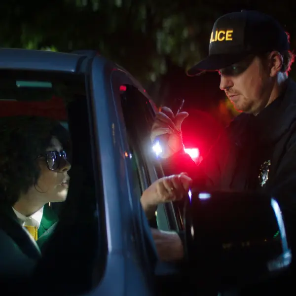 A cop aiming with a battery to a driver near his window